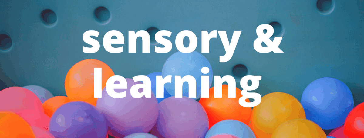 Colorful plastic balls with the words sensory & learning in bold white text overlaying the image. The background is a teal surface with circular indents.